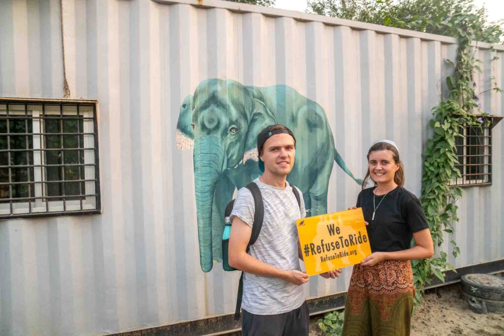 Natalia and Sam holding up a refuse to ride sign at the wildlife SOS elephant conservation centre in Agra, India